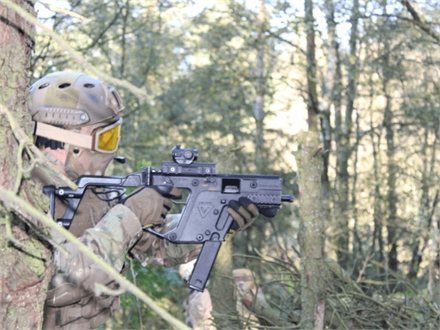 Spiller i dækning bag et træ med en Kriss Vector