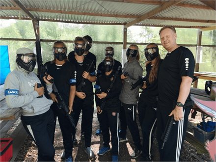 Gruppe med lejede geværer samlet under skuret